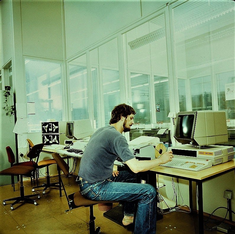 Man working on a computer in 1983